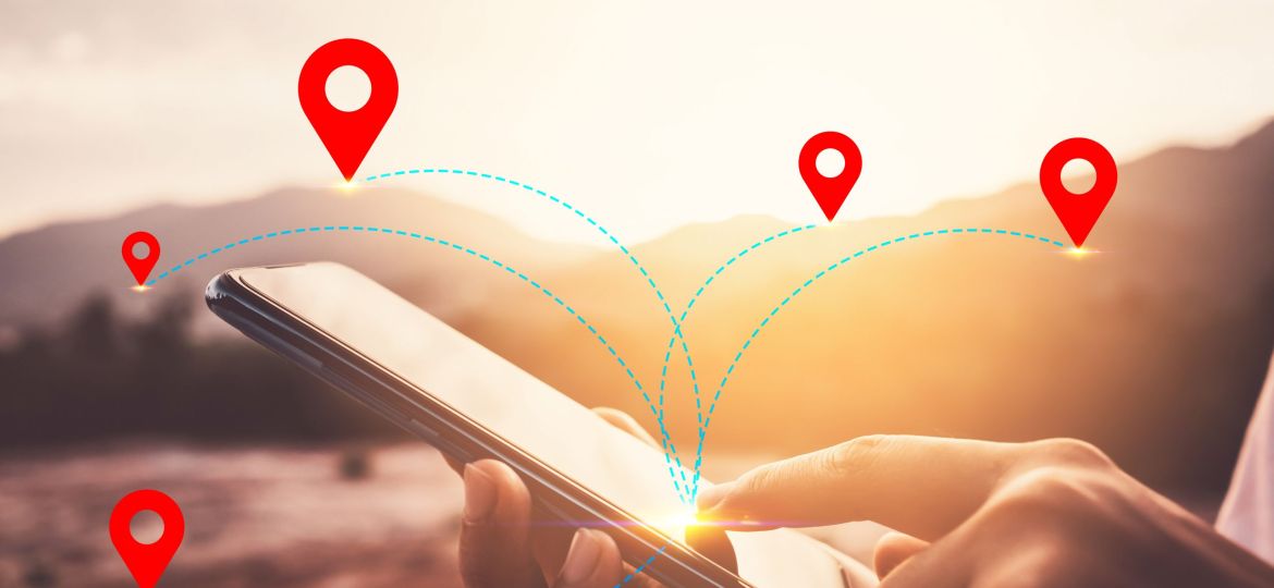 Woman hand using smart phone on top of mountain with navigator location point abstract background. Technology business and travel adventure concept.